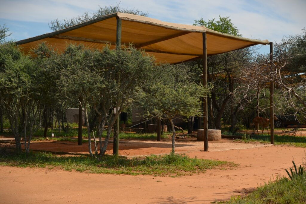 Shaded outdoor camping area at Zaagkuilsdrift Bird Sanctuary and Lodge